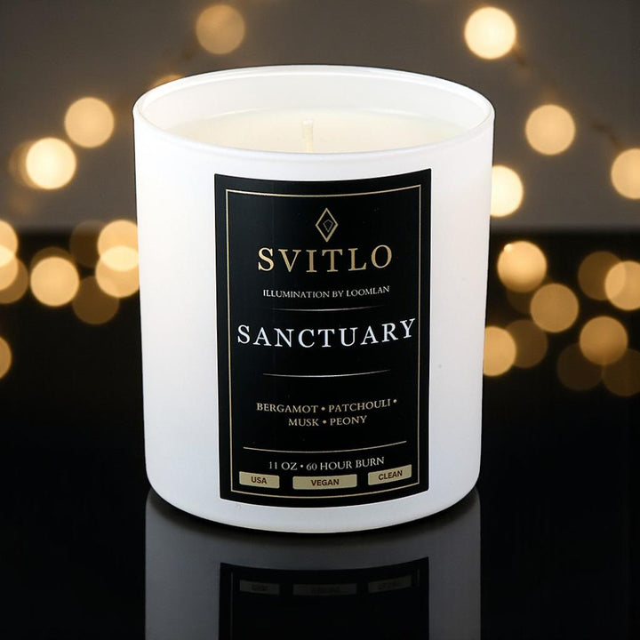Svitlo candle labeled 'Sanctuary' with a blurred lights background